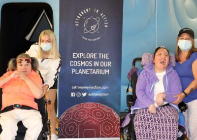 image shows two supported ladies and their staff, posing with the Astronomy in Action banner and smiling